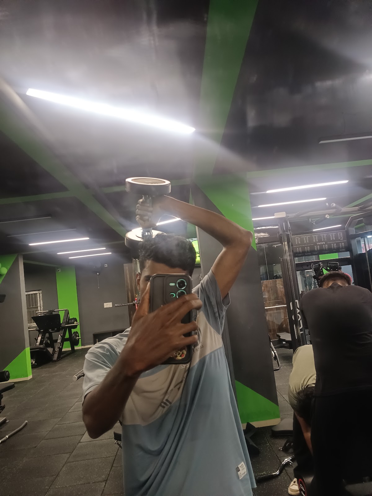 Member training with dumbbells on the gym floor