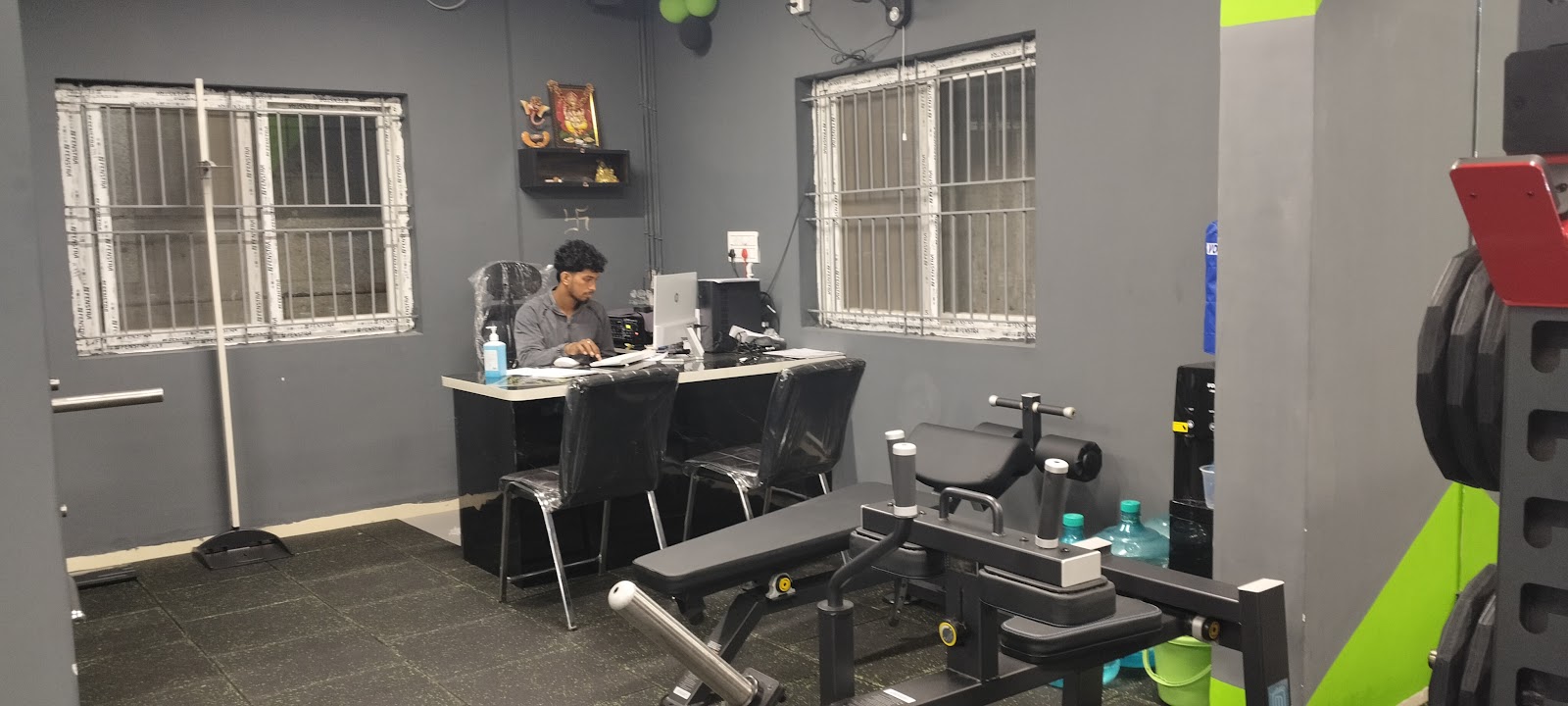 Reception desk area at 11:11 Fitness with adjacent weight bench and rack